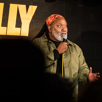 A comedian holding a microphone mid-performance at Big Belly Comedy Club.